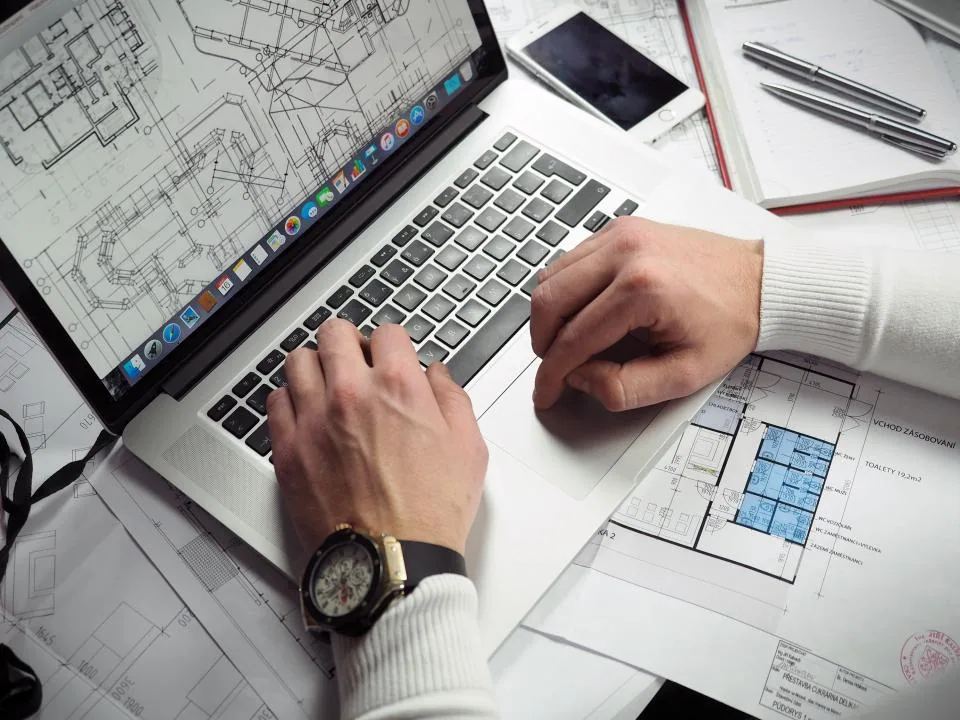Poste de travail avec un ordinateur portable ouvert sur un bureau clair