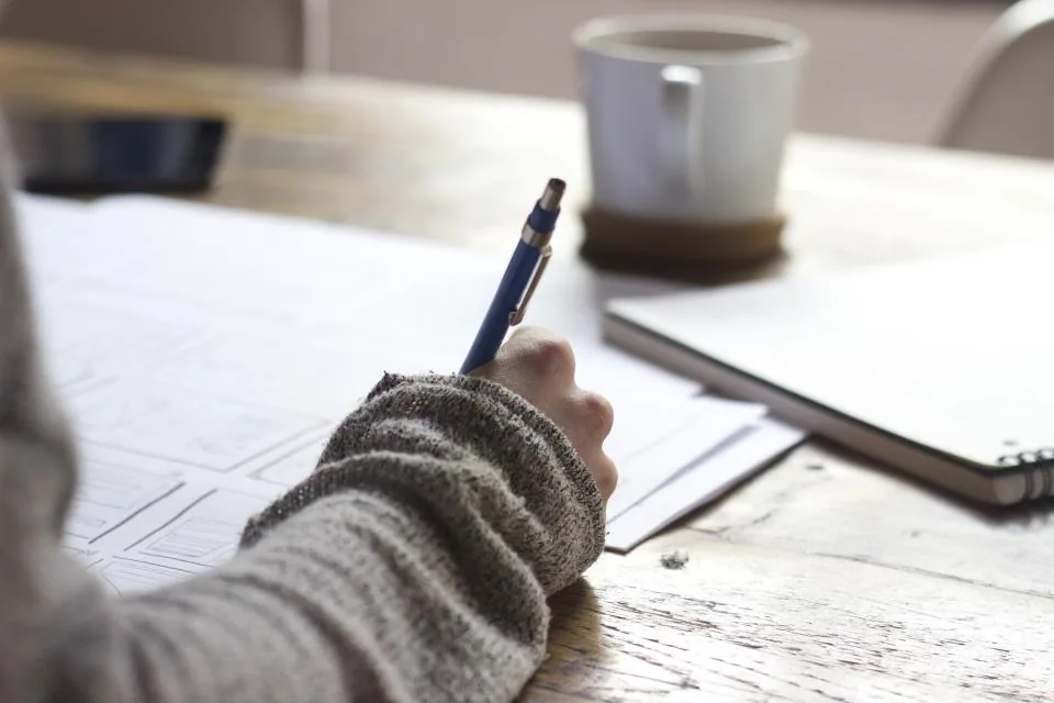 Prise de notes sur un carnet posé à côté d'un clavier
